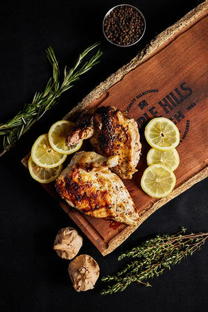 A plate of airline chicken garnished with rosemary, served on a bed of hills, showcasing a delightful culinary presentation.