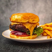 A plate featuring a Black Angus hamburger topped with cheese and fresh lettuce, ready to be enjoyed.