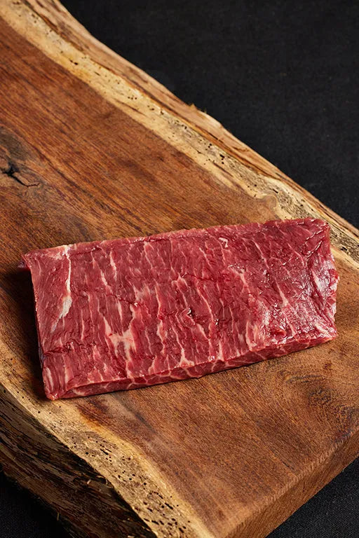 A top sirloin steak resting on a cutting board.