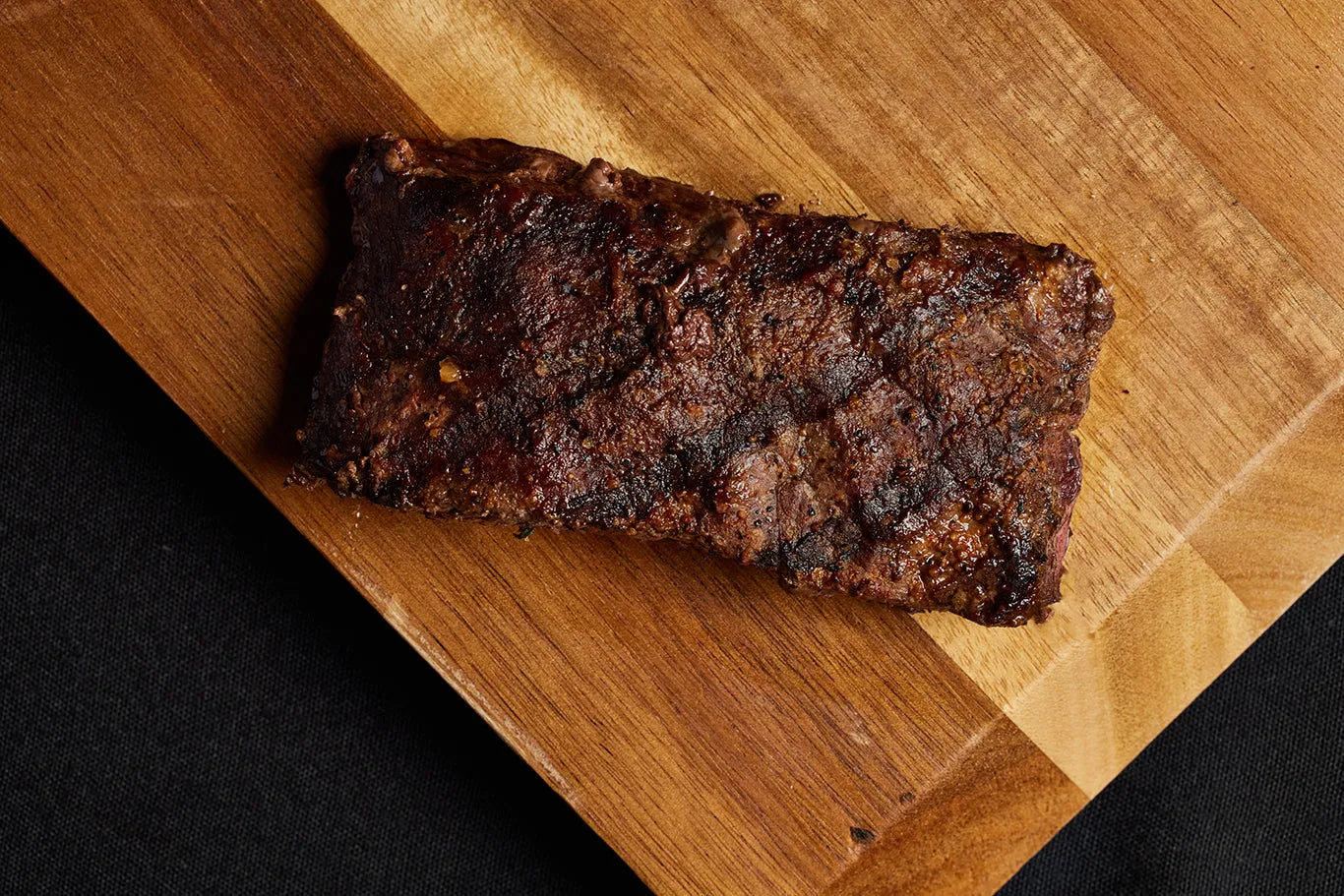 A grilled top sirloin steak resting on a cutting board.