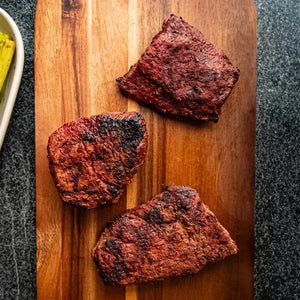 Three steak cuts on a wooden cutting board: Filet Mignon, Sirloin, and Flat Iron.