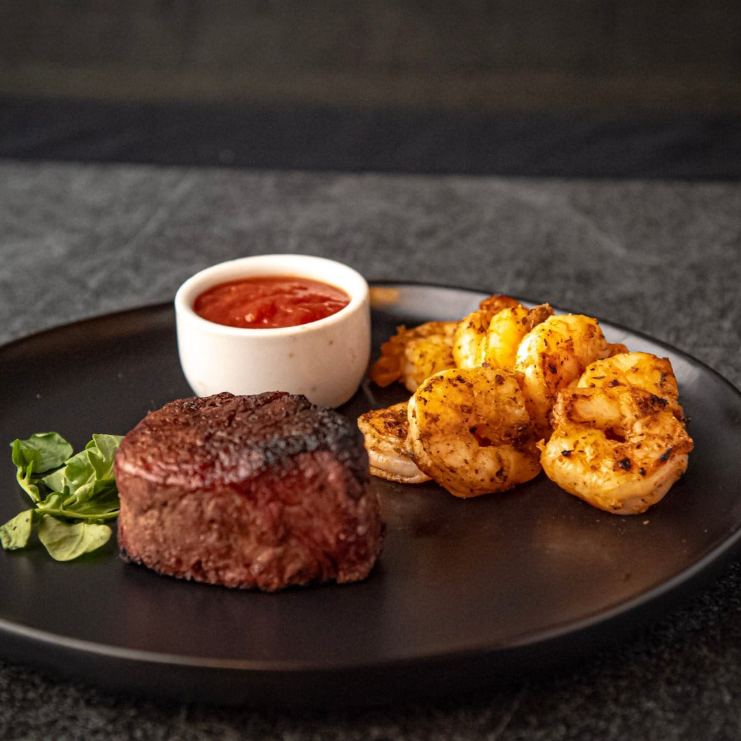 Surf & turf: shrimp and filet mignon on a plate.