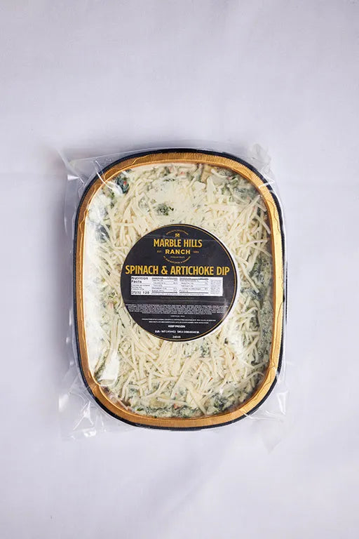 A package of spinach and artichoke dip topped with cheese.