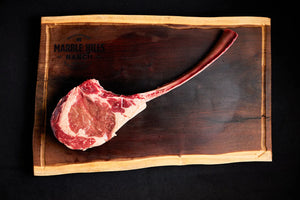 A USDA Tomahawk Ribeye steak displayed on a cutting board.